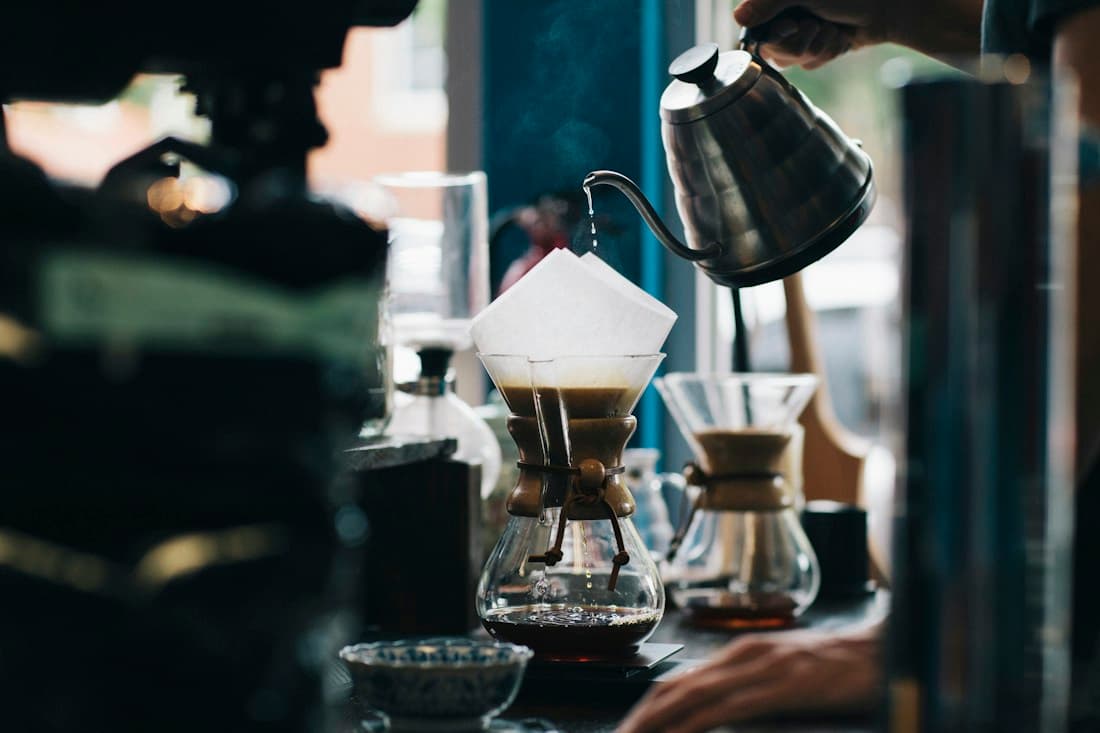 Warm coffee being prepared in a softly lit café